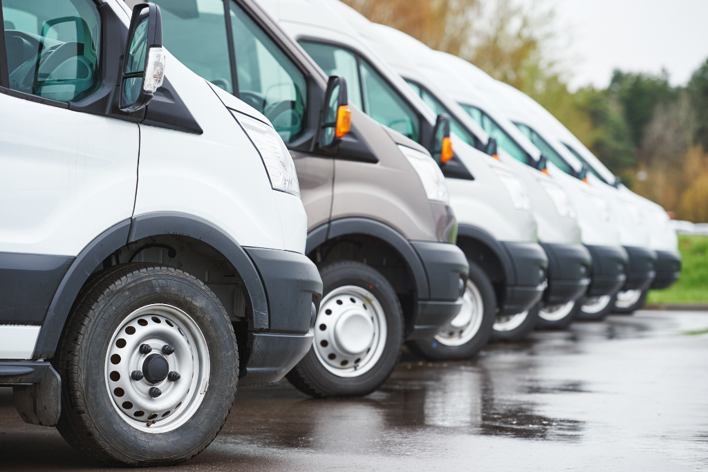 Flotă de autoutilitare aliniate într-o parcare, simbolizând diversitatea flotei și costurile variabile în transport.